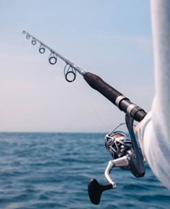 Debunking 5 Myths about Fly Fishing 1 A black and silver fly fishing rod in a person’s hand