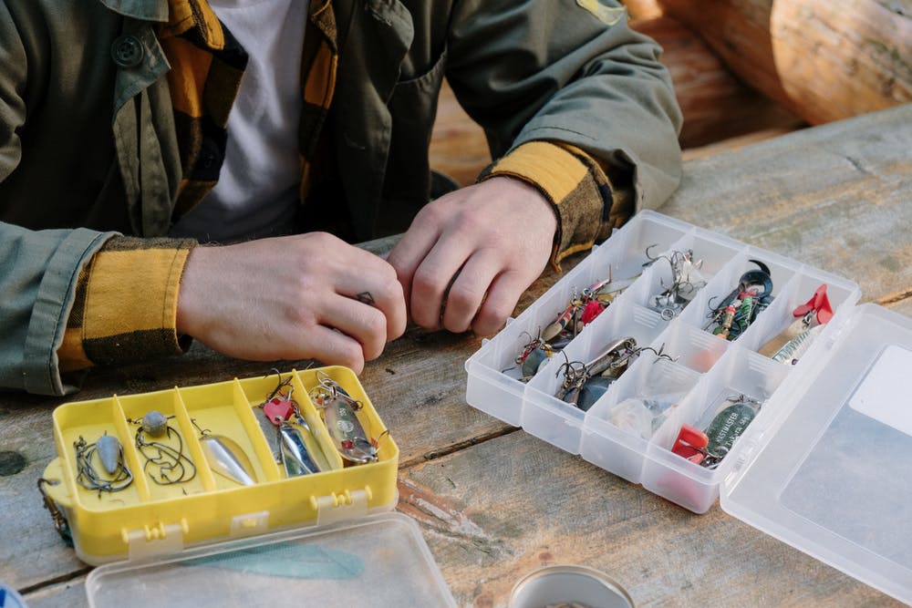 Things You Need for a Luxurious Fishing Experience 2 person in gray jacket holding clear plastic container for a fishing trip