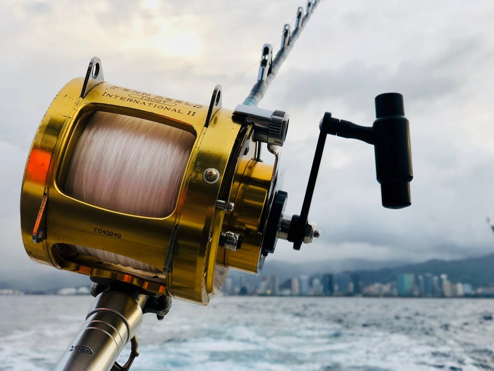 Secret Tips for Extra Luck While Fishing 2 a yellow fishing reel and the sea.