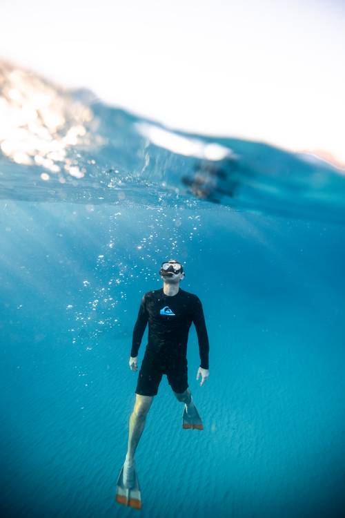 The Most Popular Water Sports That You Must Try Once 2 A man in a black swimsuit and snorkeling gear in the sea.